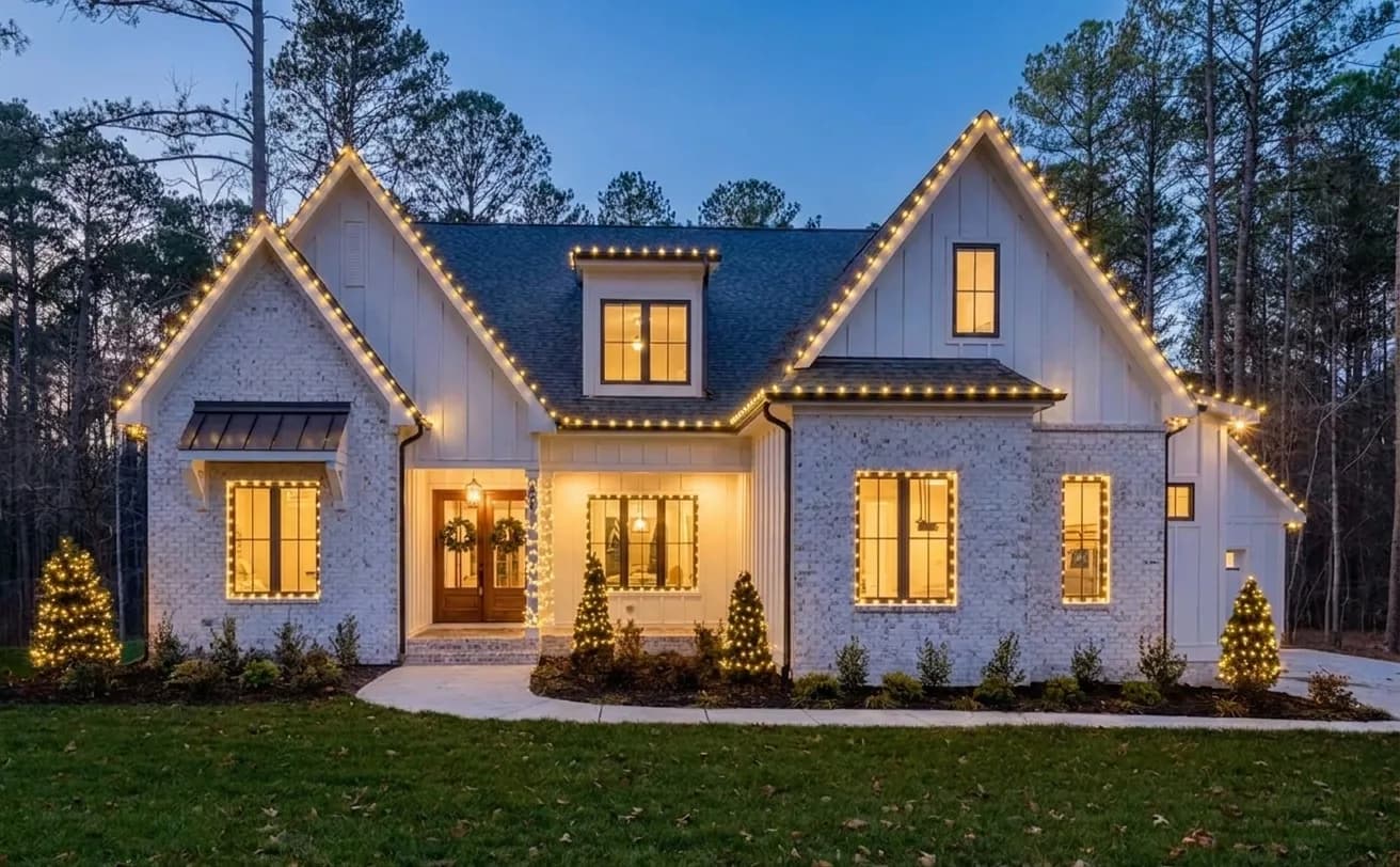 A real home rendered at dusk with professional warm white Christmas lights along the rooflines